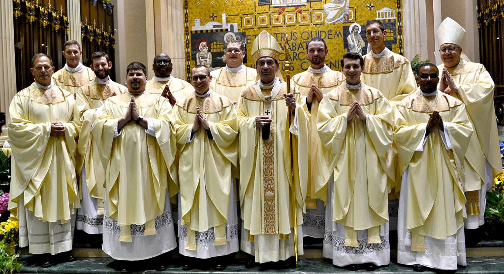 Front Row from L to R Father Anthony Brausch, Father Mark Bredstege, Father Jeff Stegbauer, Archbishop Dennis M. Schnurr, Father Andrew Hess, Father Alex Biryomumeisho; Back Row L to R, Father Ambrose Dobrozsi, Father Elias Mwesigye, Father Zach Cecil, Father Jedidiah Tritle, Father Christian Cone-Lombarte, and Bishop Joseph Binzer (CT Photo/Greg Hartman)