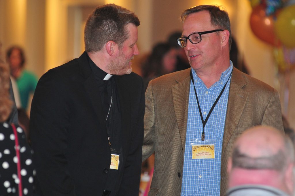 Fr.Bob Jones, Chaminade Julienne HS and John Marshall also from CJHS socialize prior to supper being delivered (CT Photo/Jeff Unroe)