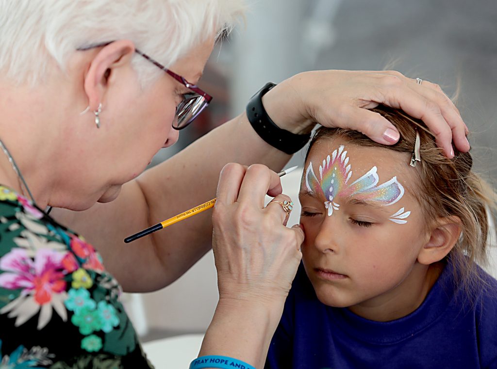 Theresa Morris paints the face of Marie Hicks, 5, during the Cross the Bridge for Life in Newport, Ky. Sunday, June 2, 2019. (CT Photo/E.L. Hubbard)
