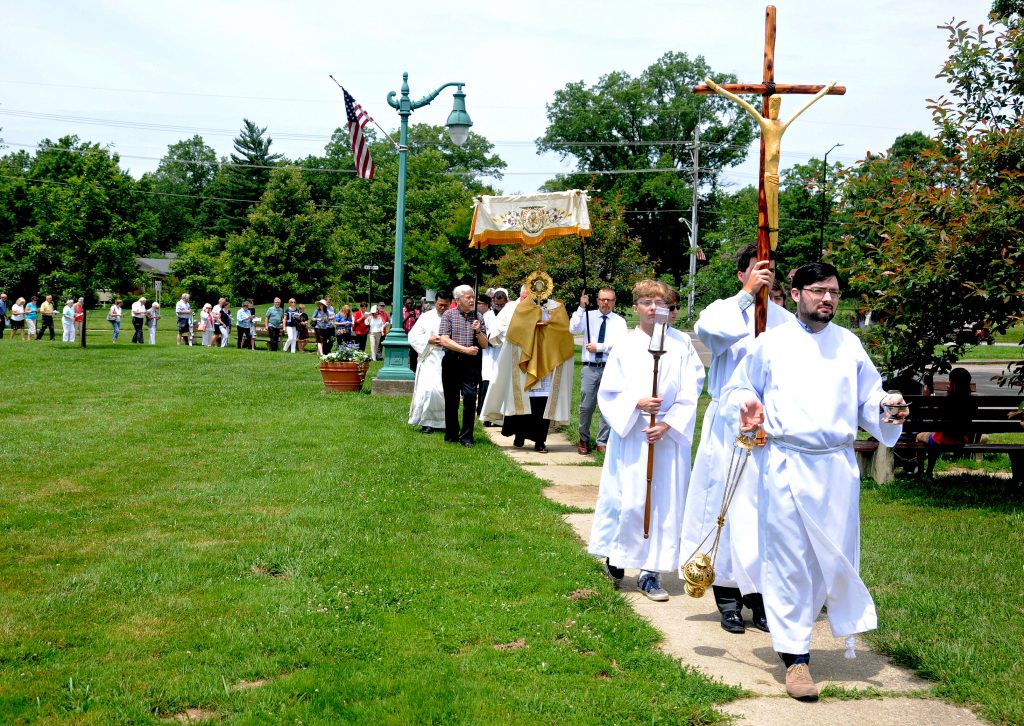 Our Lady of the Rosary parishioner Joshua Vietas leads the congregation around the Greenhills Commons during the parish's Fourth Annual Feast of Corpus Christi Procession on Sunday, June 23. Members of the church process to the Commons's gazebo where the Blessed Sacrament is displayed during a brief service. Following a homily by Our Lady of the Rosary pastor, Fr. Alex McCullough, the Blessed Sacrament is returned to the church for a final blessing and placed in the tabernacle. (CT Photo/ David A. Moodie,)