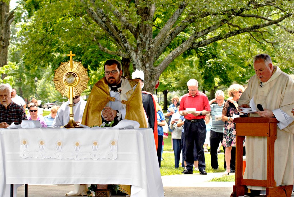 Father Alex McCullough, pastor of Our Lady of the Rosary in Greenhills, kneels before the Blessed Sacrament as the congregation sings a hymn during the church's Fourth Annual Feast of Corpus Christi Procession on Sunday, June 23. (CT Photo/David A. Moodie)