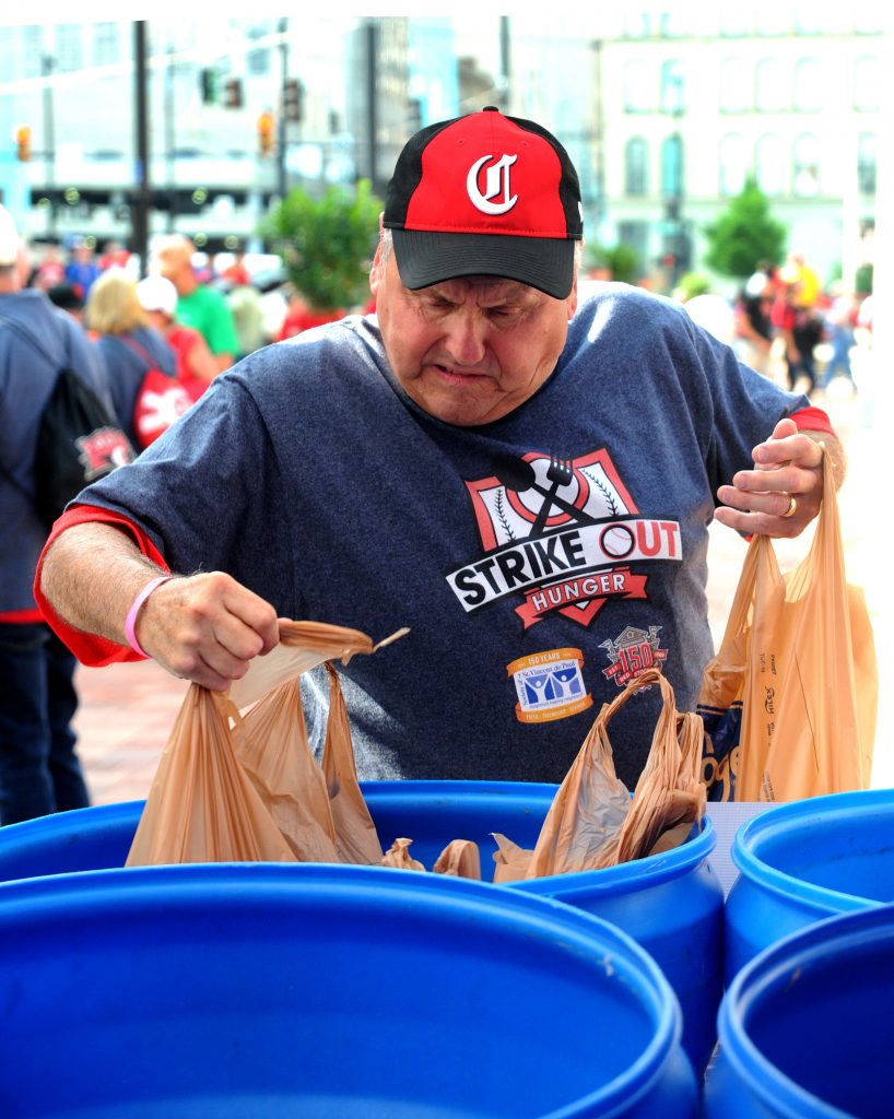 St. Vincent de Paul volunteer Steve Taylor places bags  of donated food into a collection bin outside of Great American Ballpark on Friday, May 31. SVdP collected food from patrons of the Reds games on Friday and Saturday, May 31 and June 1, during  their “Strike Out Hunger" campaign. Game patrons who donated three or more non-perishable foods were awarded tickets to  a future Reds game. Last year’s drive collected over three tons of food, which fed approximately 5,300 families. (CT photo/David A. Moodie)