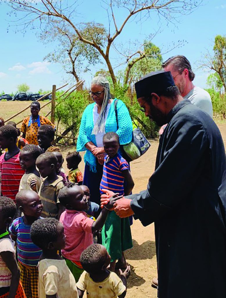 Abba Habtesilassie Antuan, General Secretary of Eparchy of Emdibir Catholic Secretariat, is pictured with Rita Winters and the group of Cincinnati visitors, as he checks in with a low-income area of his parish where sharecroppers are struggling to earn enough money to stay alive.
