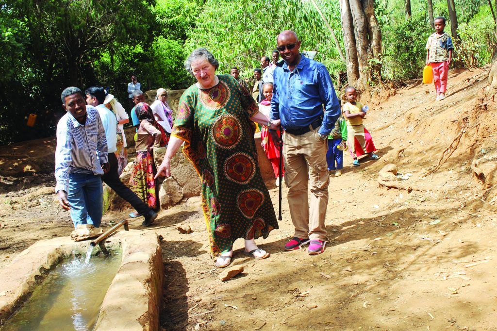 Medical Mission Sister Elaine Kohls and local residents visit a well in rural Ethiopia.