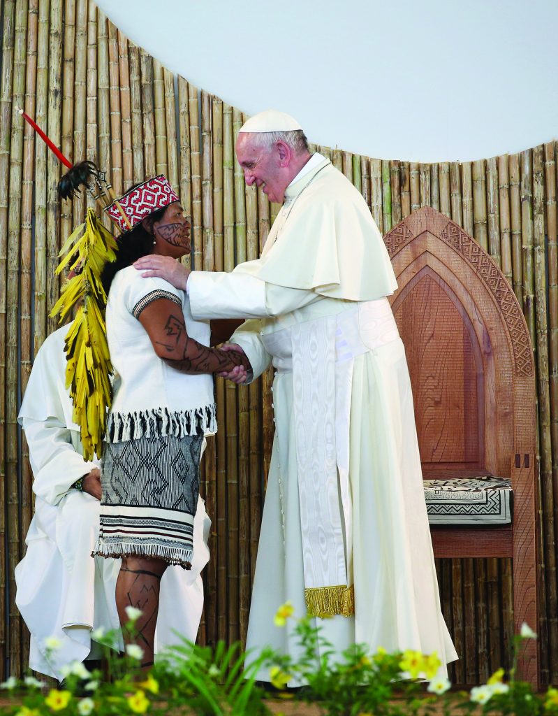Pope Francis is greeted by a member of an indigenous group from the Amazon region during a meeting at the Coliseo Regional Madre de Dios in Puerto Maldonado, Peru, Jan.19, 2018. The upcoming Synod of Bishops on the Amazon is an "urgent" gathering, not of scientists and politicians, but for the church whose main focus in discussions will be evangelization, Pope Francis said in a new interview. (CNS photo/Alessandro Bianchi, Reuters)