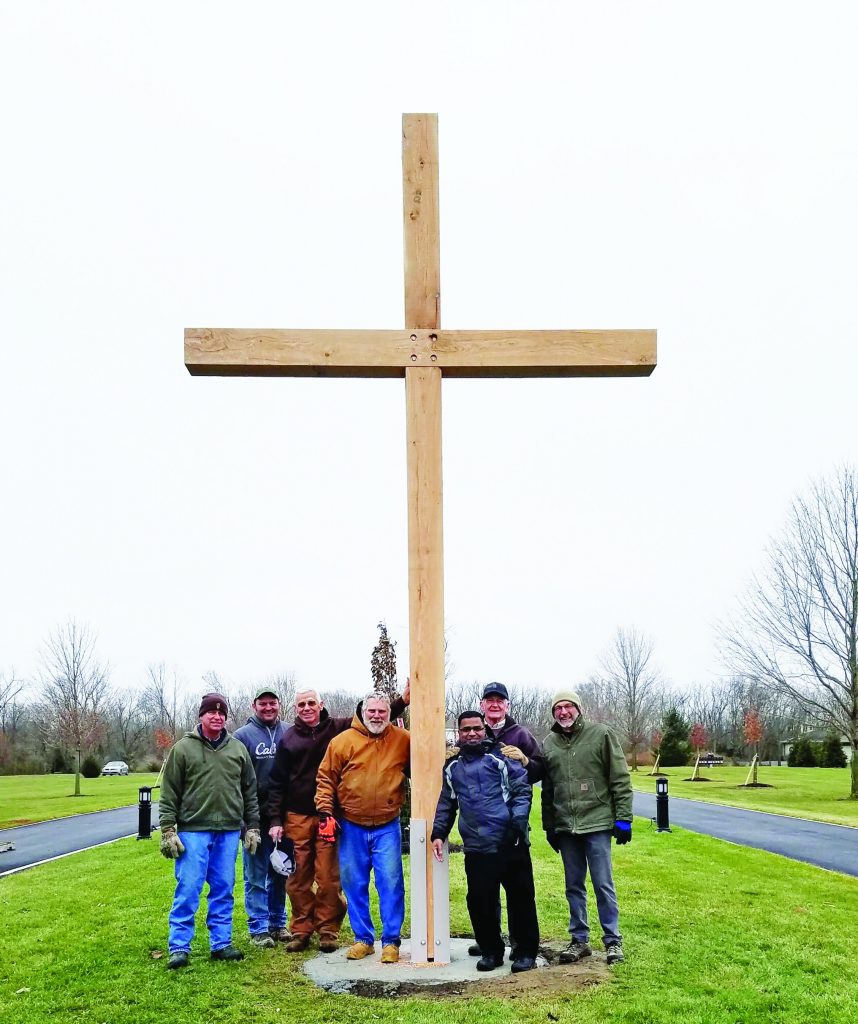 Joe Fisher, Ben Dull, Bill Platfoot, John Marchal, Father Michael Samala, Dennis Hile, and Bob Iiames with the cross built from tornado debris