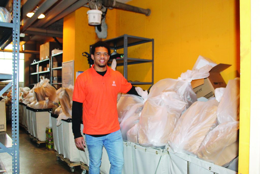 St. Joseph Orphanage’s Behavior Support Specialist, Willie Wright, packs bags of food alongside other education team members to be delivered to the homes of students.