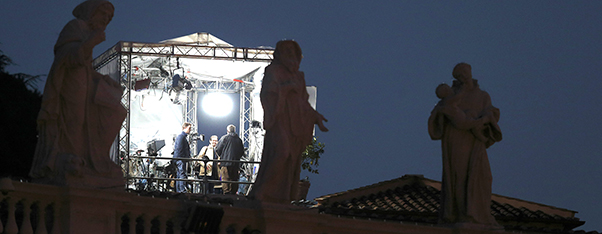 Television crew works in tent overlooking colonnade at Vatican