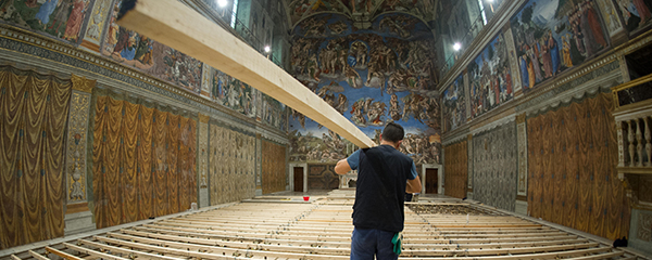 Worker carries in timber as Sistine Chapel is prepared for conclave