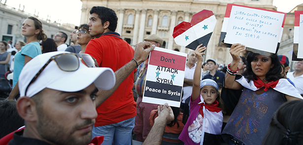 People from Syria hold up signs before pope leads prayer vigil for peace