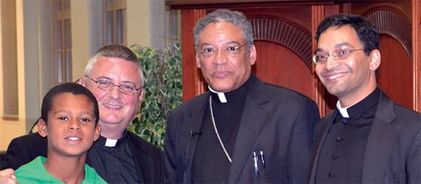 More than 100 people gathered at the Athenaeum Monday to hear Most Reverend Joseph N. Perry, Auxiliary Bishop of the Archdiocese of Chicago (second from right) discuss the possibility of sainthood for Father Augustus Tolton, a former slave and the first identified priest of African descent in the United States. Bishop Perry is the postulant for Tolton’s sainthood. Pictured from left is Andrew Hilgefort, Father Benedict O’Cinnsealaigh, Rector of Mount Sr. Mary’s Seminary of the West and President of the Athenaeum, Bishop Perry and Father Earl Fernandes, Dean of the Athenaeum. (CT Photo/Steve Trosley)