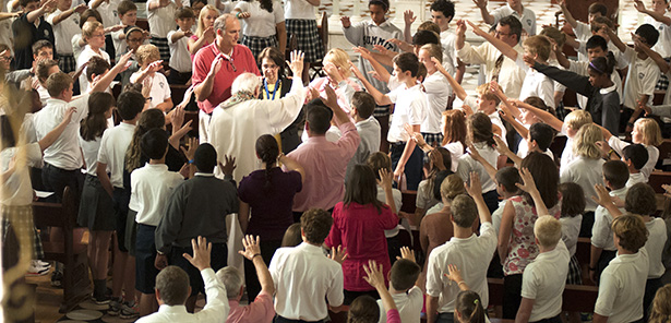 Summit Middle School students and other members of the school community gather around religion teacher Penny Herr as she recieves the sacrament of the Annointing of the Sick. (Courtesy Photo)