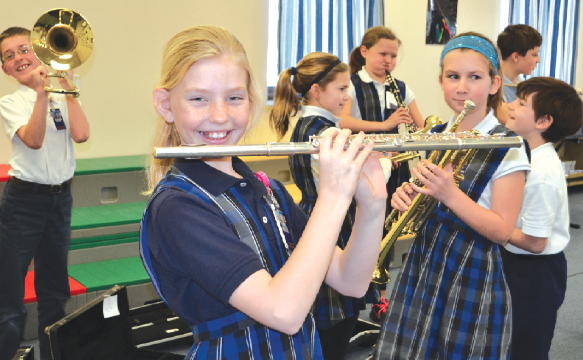 Sidney Stigler (with flute) and other St. Ignatius students get their first look at some of the instruments recently donated to the music program. (CT Photo/John Stegeman)