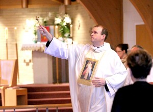 Father Eric Bowman sprinkles Holy Water while blessing the congregation during the special Mass at St. Adalbert Parish in Dayton Sunday, April 27, 2014, to celebrate the Canonizations of Pope John Paul II and Pope John XXIII. (CT Photo/E.L. Hubbard)