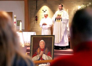 A framed portrait of Pope John Paul II sits in front of the altar as Father Eric Bowman gives the closing blessing during the special Mass at St. Adalbert Parish in Dayton Sunday, April 27, 2014, to celebrate the Canonizations of Pope John Paul II and Pope John XXIII. (CT Photo/E.L. Hubbard)