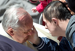 A young man touches the cheek of Pope Francis during the pontiff's weekly audience in St. Peter's Square at the Vatican May 14. (CNS photo/Claudio Peri, EPA)