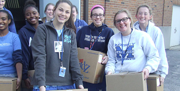 Mother of Mercy High School Students pose with canned goods collected for the needy. (Courtesy Photo/Mercy High School)