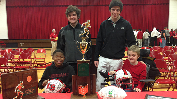 John Junker, left in back, and his brother Jake were counselors for Jacoby Gilliam, left in front, and Michael Overberg at Camp Campbell Gard this summer for the Muscular Dystrophy Association. The four are in back of La Salle’s state Division II football championship trophy. (Courtesy Photo/La Salle High School)