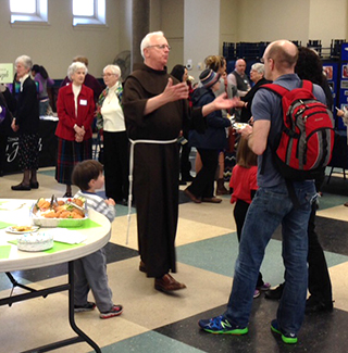 A Franciscan Friar speaks with parishioners at an event hosted at St. Monica-St. George April 26. (Courtesy Photo)