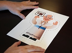 A Washington-based editor sizes up a cartoon image of Pope Francis June 24. Catholic Extension created "Flat Francis" to help people welcome the pontiff when he makes his U.S. visit in September. (CNS photo/Chaz Muth) 