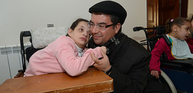 Bishop Oscar Cantu of Las Cruces, N.M., interacts with a Palestinian girl Jan. 14 in the Hogar Nino Dios, a home for abandoned and disabled children in Bethlehem, West Bank. (CNS photo/Debbie Hill) 