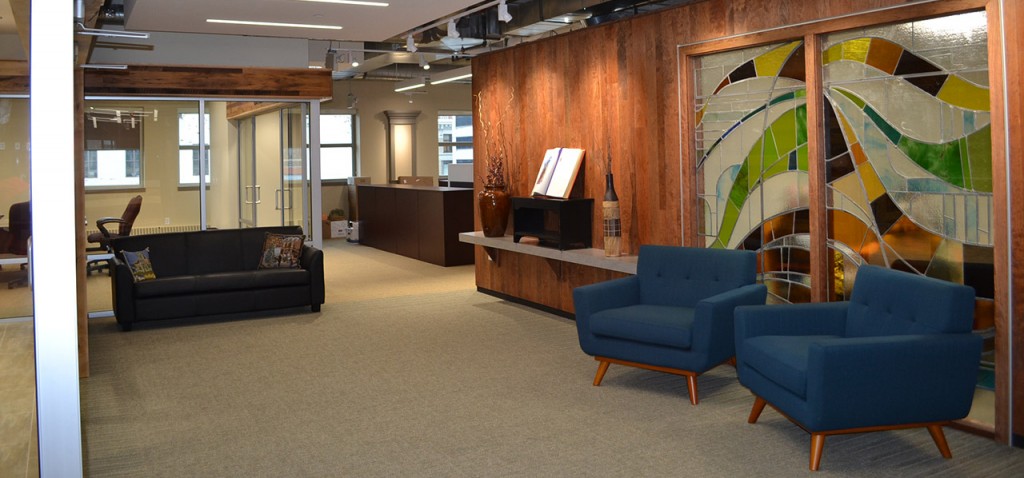 The main lobby on the newly renovated 9th floor of the Archdiocese of Cincinnati central offices includes reclaimed lumber and a donated stained glass window, as well as a prominent place to feature the Word of God. (CT Photo/John Stegeman)
