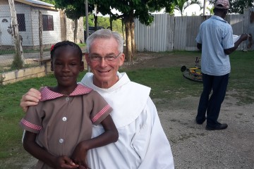 Franciscan Father Jim Bok poses with a Jamaican child. (Courtesy Photo)