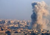 Smoke rises from a government-held area of Aleppo, Syria, after a Dec. 12 explosion. (CNS photo/Omar Sanadiki, Reuters)