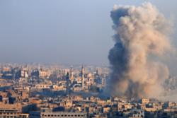 Smoke rises from a government-held area of Aleppo, Syria, after a Dec. 12 explosion. (CNS photo/Omar Sanadiki, Reuters)