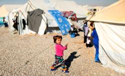 A displaced Iraqi child walks outside tents Dec. 9 at the Hassan Sham camp near Mosul. As Christians in the Middle East look back on 2016, they wonder if there will be much to celebrate amid mounting challenges, particularly for those displaced by conflicts in Iraq and Syria. (CNS photo/Ahmed Jadallah, Reuters)