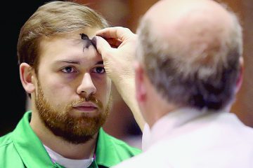 Mike Wolf marks a parishioner’s forehead with the sign of a cross during Ash Wednesday services at St. Peter in Chains Cathedral in Cincinnati Wednesday, Mar. 1, 2017. (CT PHOTO/E.L. HUBBARD)