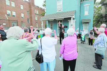 Rev. Michael Pucke. pastor of St. Julie Billiart Catholic Parish in Hamilton, leads a cheer to Sr. Dorothy during the blessing of “The Sr. Dorothy Stang House”, a house for homeless families, during a dedication ceremony in Hamilton Saturday, May 27, 2017. (CT Photo/E.L. Hubbard)