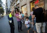 A police officer helps evacuate people after a van crashed into pedestrians in the Las Ramblas district of Barcelona, Spain, Aug. 17. Terrorists killed at least 12 and injured more than 50 others. (CNS photo/Ana Jimenez, La Vanguardia via Reuters)