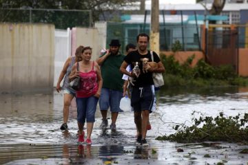 People walk in a flooded street Sept. 21 in Toa Baja, Puerto Rico, in the aftermath of Hurricane Maria. (CNS photo/Thais Llorca, EPA)