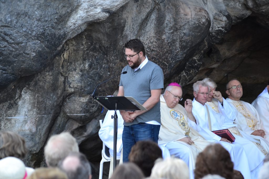 Sean Ater, New Evangelization Director, reads the first reading at the English speaking Mass at Lourdes, September 29, 2017 (CT Photo)