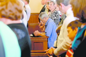 A parishioner kneels in prayer during the Feast of St. Bernard Mass and the closing of the One Hundred and Fiftieth Anniversary Year at St. Bernard of Clairvaux Catholic Church in Cincinnati Saturday, Aug. 19, 2017. (CT Photo/E.L. Hubbard)