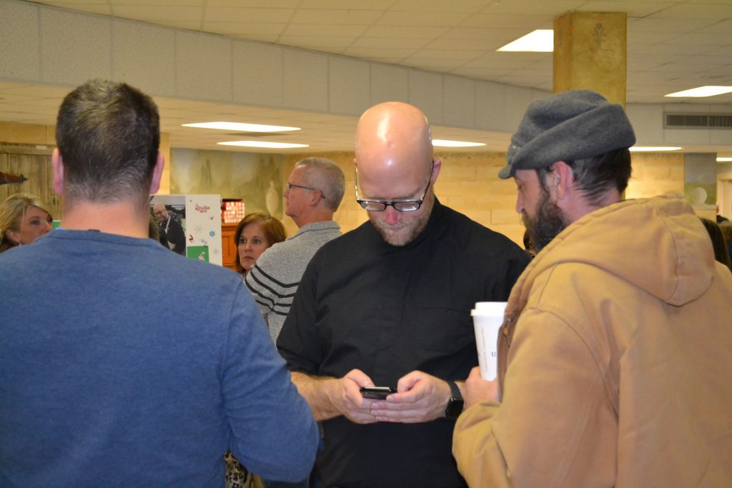 Father Kyle receiving text well-wishers prior to The Great American Baking Show. (CT Photo/Greg Hartman)