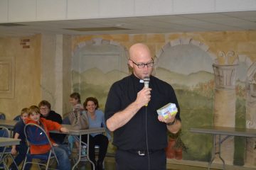 Father Kyle Schnippel giving the viewing party participants a primer before the show. (CT Photo/Greg Hartman)