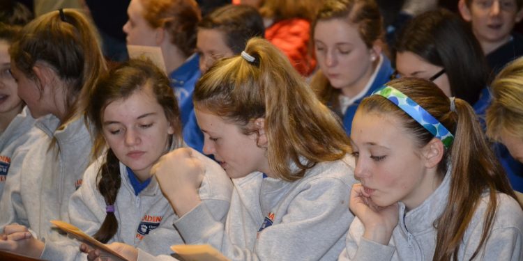 Students looking over the program for the Catholic Schools Week Mass (CT Photo/Greg Hartman)