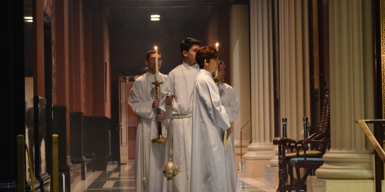 Karen Kane, Liturgy Coordinator and Director of Office for Divine Worship & Sacraments in the Archdiocese of Cincinnati, directs Acolytes before the Gospel reading. (CT Photo/Greg Hartman)