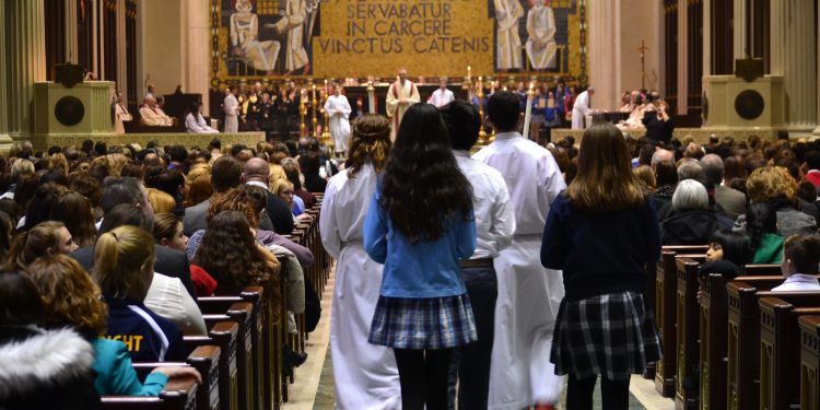 Gift Bearers Nicole Abughosh Our Lady of Grace School, Matthew Carmen-Ugaz St. Gertrude, and Cate Donbar St. Vincent Ferrer bring up the gifts. (CT Photo/Greg Hartman)