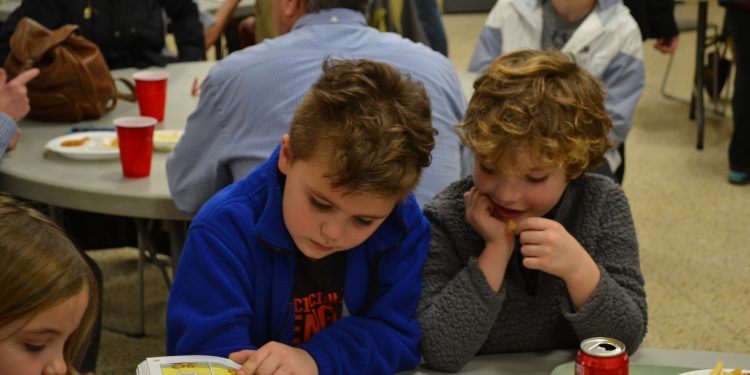 Having fun and reading a picture book at the St. Cecilia Fish Fry 2018 (CT Photo/Greg Hartman)