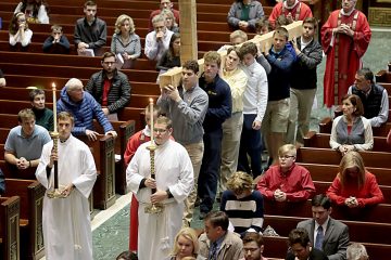 Students from Cincinnati Moeller High School carry the Holy Cross for the Celebration of the Passion of the Lord at the Cathedral of St. Peter in Chains in Cincinnati on Good Friday, Mar. 30, 2018. (CT Photo/E.L. Hubbard)
