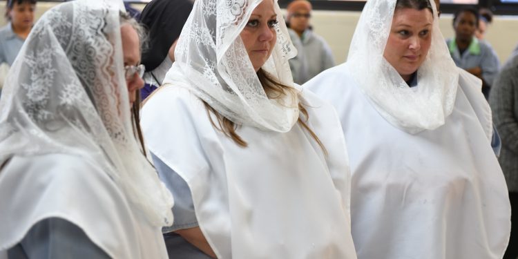 Newly baptized members Teri, Lee Anna and Mincey at Easter Mass (CT Photo/Mark Bowen)