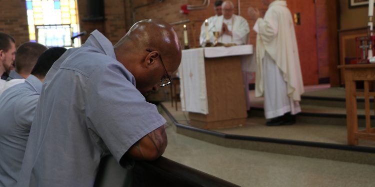 Inmates pray during the Eucharistic Prayer at Lebanon Correctional during Easter Vigil (CT Photo/Tom Uhlman)