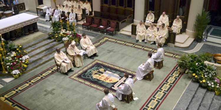 Deacons Craig Best, Jarred Kohn, Andrew Smith, & Jacob Willig listen to the homily of Archbishop Schnurr. (CT Photo/Greg Hartman)