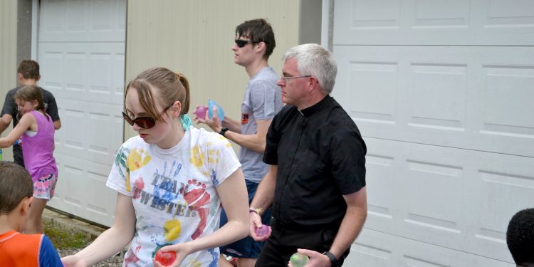 Father Tim Ralston aims and fires during Totus Tuus fun afternoon. (CT Photo/ Greg Hartman)