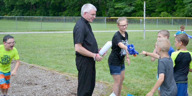 Father Tim Ralston enjoying the afternoon, beware of what lurks behind! (CT Photo/Greg Hartman)