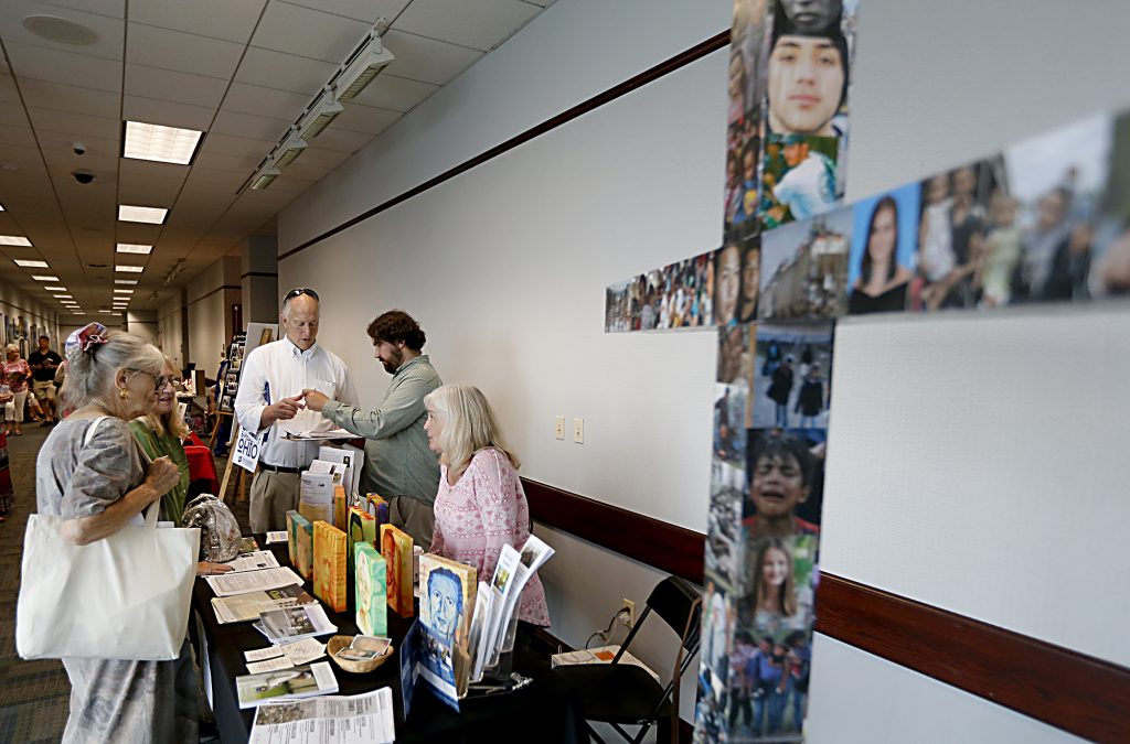 Kathy Kohl, right, from Bellarmine Chapel, speaks with a guest during the first Festival of Faiths at the Cintas Center in Cincinnati Sunday, June 24, 2018. (CT Photo/E.L. Hubbard)