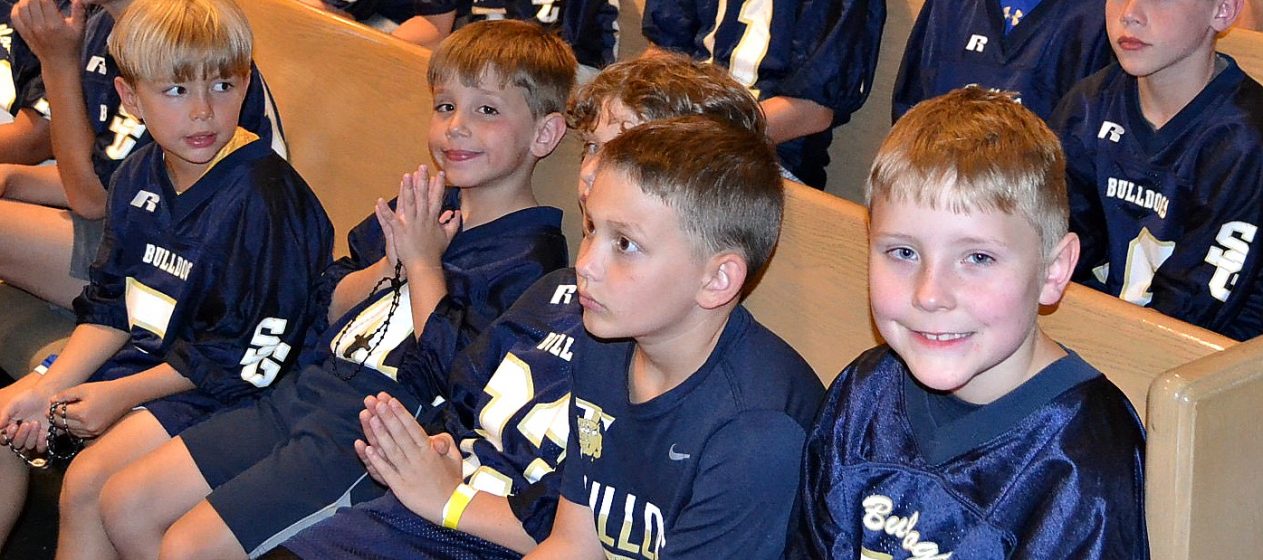 Boys from the St. Gertrude Football squad await praying the rosary. (CT Photo/Greg Hartman)